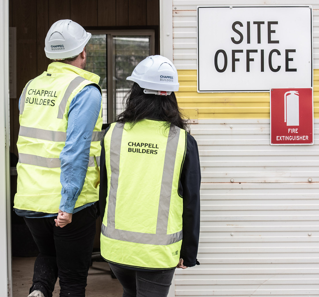 Two workers enter site office